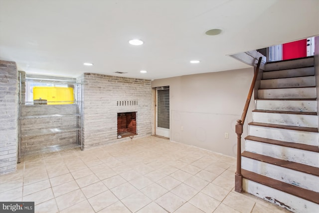 basement featuring a fireplace and light tile patterned floors