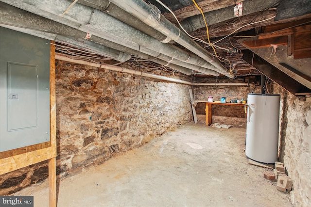 basement featuring electric panel and gas water heater