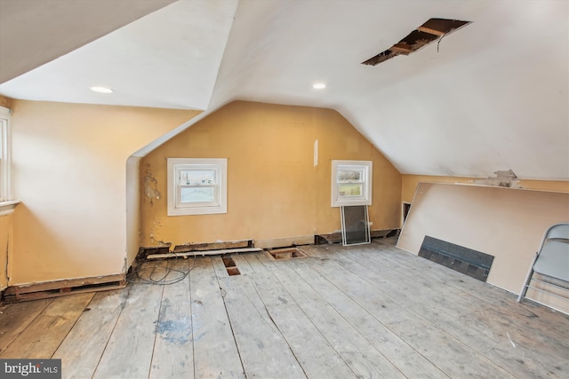 additional living space with light wood-type flooring and lofted ceiling