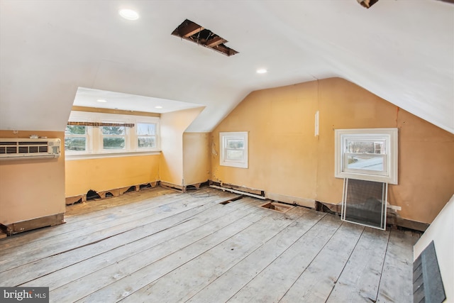 bonus room with lofted ceiling, wood-type flooring, and an AC wall unit