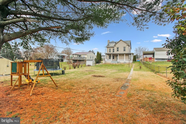 view of yard with a trampoline and a playground