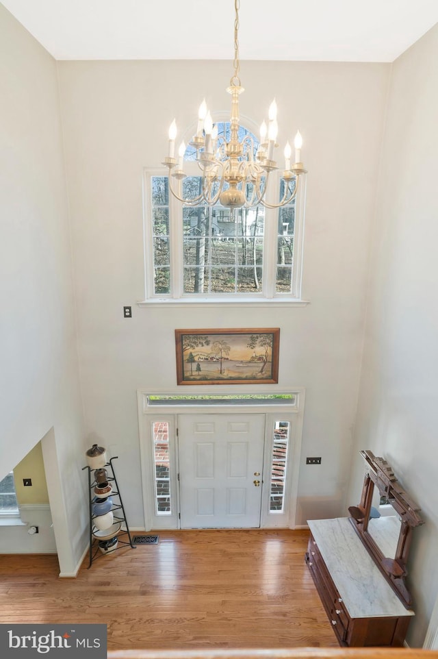 foyer entrance featuring hardwood / wood-style flooring and a notable chandelier