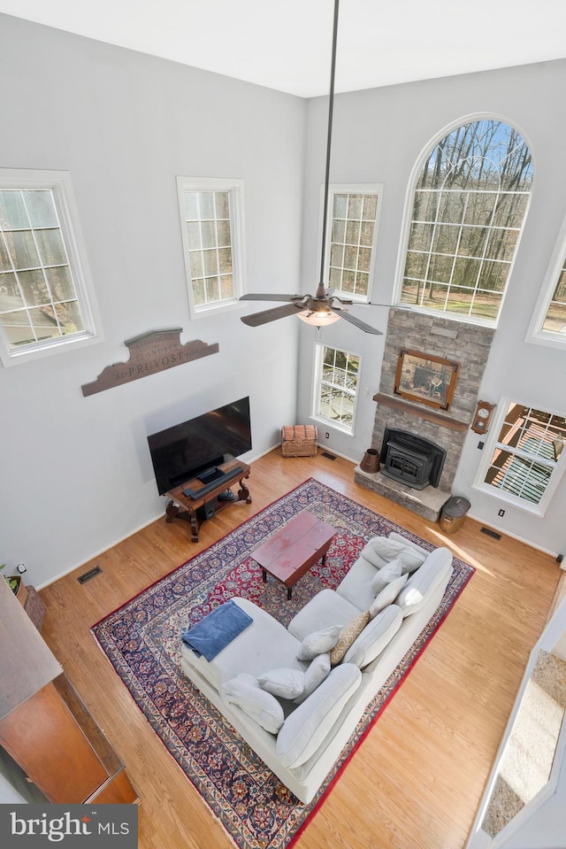 living room featuring ceiling fan, wood-type flooring, and a fireplace