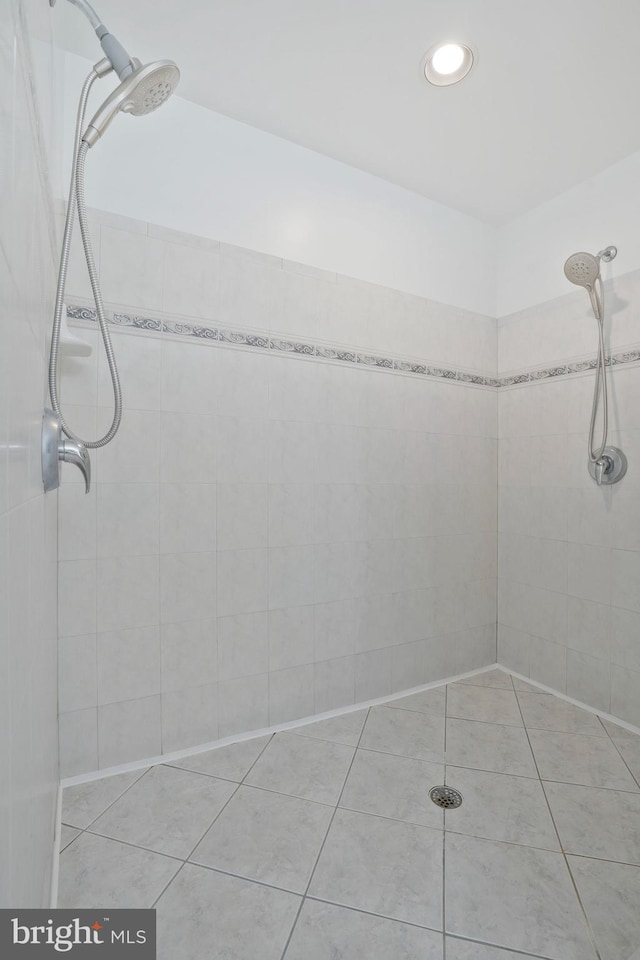 bathroom with tiled shower and tile patterned floors