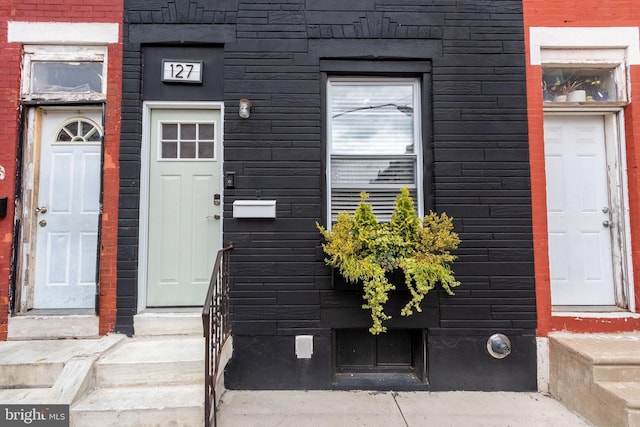 doorway to property featuring brick siding