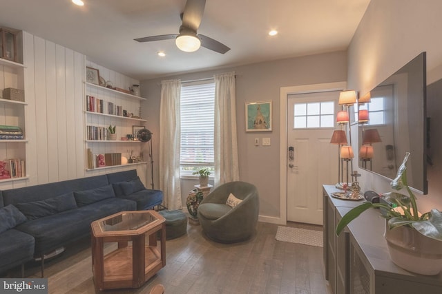 living room with ceiling fan and dark hardwood / wood-style flooring