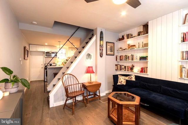 living area with ceiling fan and dark hardwood / wood-style flooring