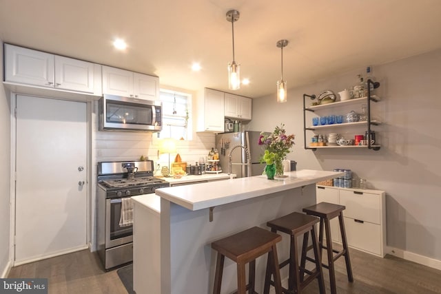 kitchen featuring a breakfast bar, dark hardwood / wood-style floors, white cabinetry, and stainless steel appliances