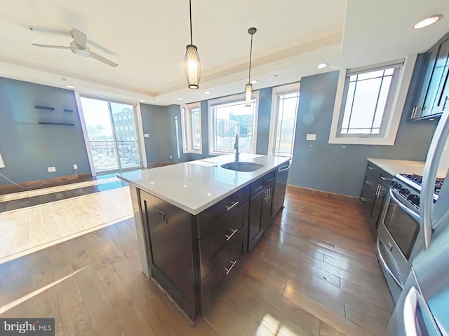 kitchen featuring sink, a center island, stainless steel appliances, decorative light fixtures, and hardwood / wood-style flooring