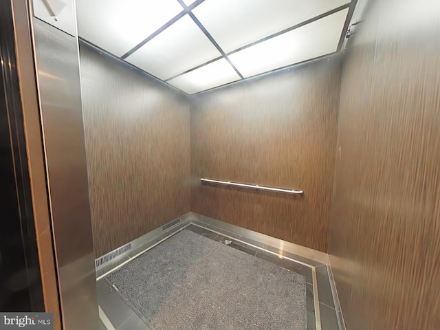 interior space featuring elevator and wood walls