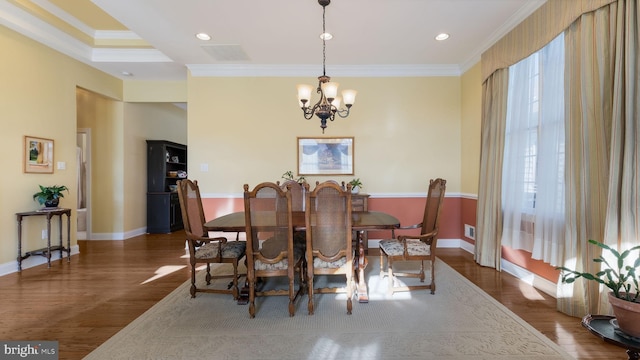 dining space featuring a chandelier, dark wood-type flooring, and crown molding