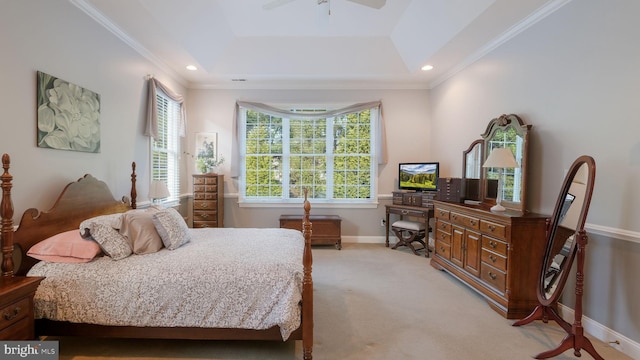 carpeted bedroom with a tray ceiling, ceiling fan, and ornamental molding