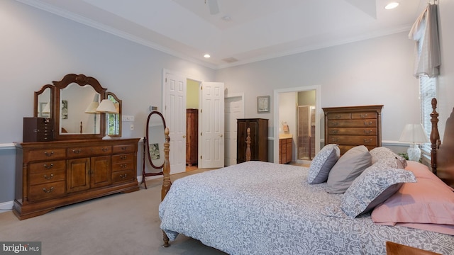 carpeted bedroom with a tray ceiling, ensuite bath, ceiling fan, and crown molding