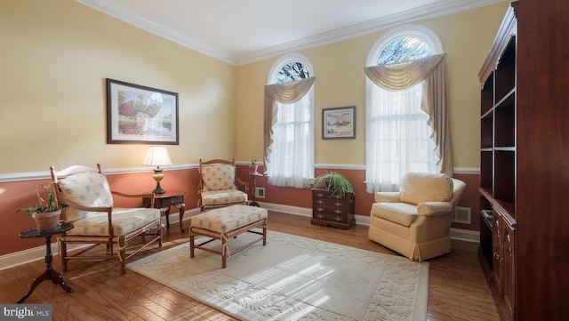 sitting room with crown molding, light hardwood / wood-style flooring, and plenty of natural light