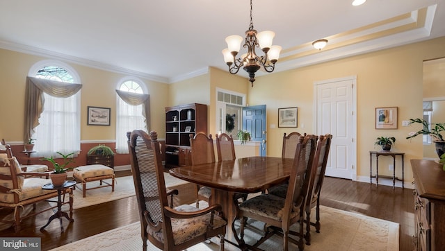 dining room featuring ornamental molding, an inviting chandelier, and dark wood-type flooring