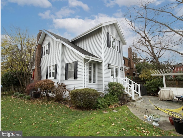 view of home's exterior with a lawn and a patio