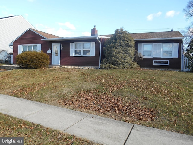 single story home featuring a chimney and a front yard