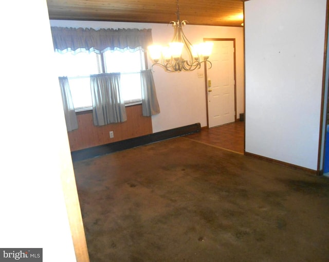 empty room with a chandelier, dark colored carpet, wood ceiling, and baseboards