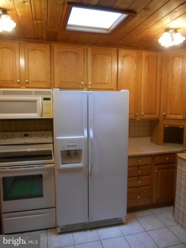 kitchen featuring light tile patterned floors, light countertops, brown cabinetry, wood ceiling, and white appliances