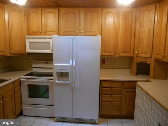 kitchen featuring light tile patterned floors, light countertops, white appliances, and tasteful backsplash