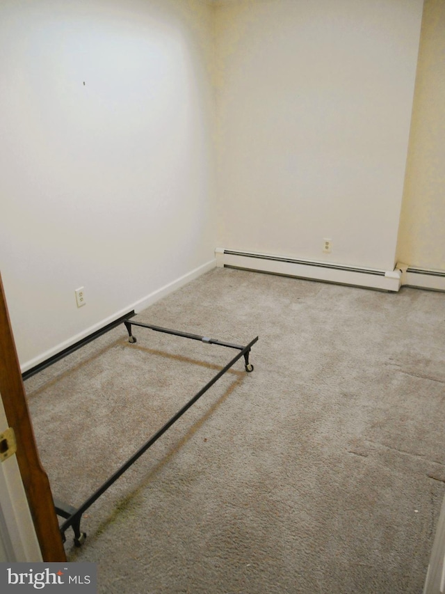 carpeted empty room featuring a baseboard radiator