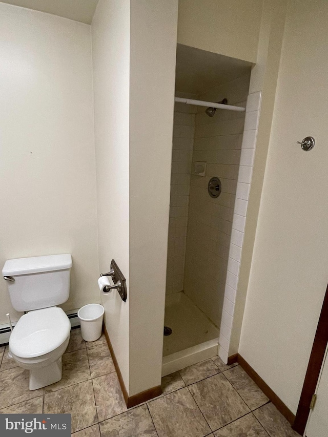 full bathroom with toilet, a shower stall, baseboards, and a baseboard radiator