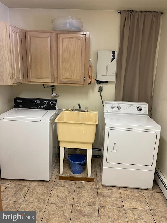 clothes washing area featuring light tile patterned floors, cabinet space, a baseboard radiator, washing machine and dryer, and a sink