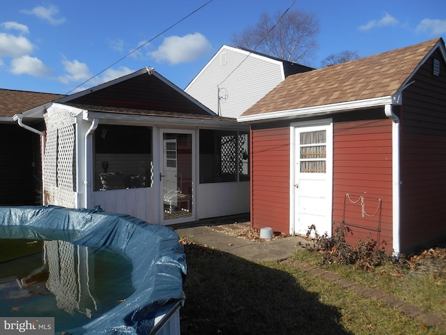 rear view of house with roof with shingles