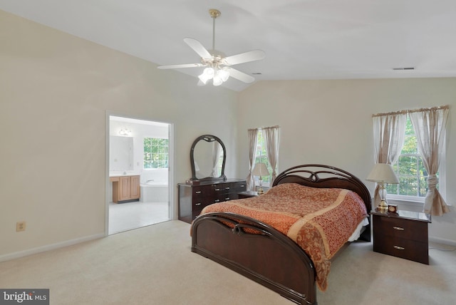 carpeted bedroom with ceiling fan, lofted ceiling, connected bathroom, and multiple windows