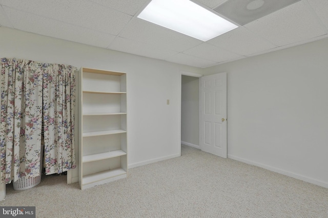 unfurnished bedroom featuring a drop ceiling and carpet floors