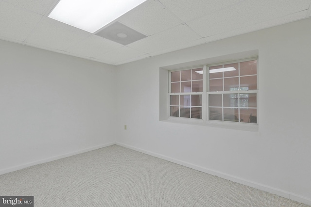 spare room with a drop ceiling and carpet