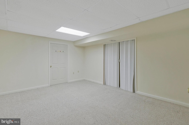 carpeted spare room with a drop ceiling