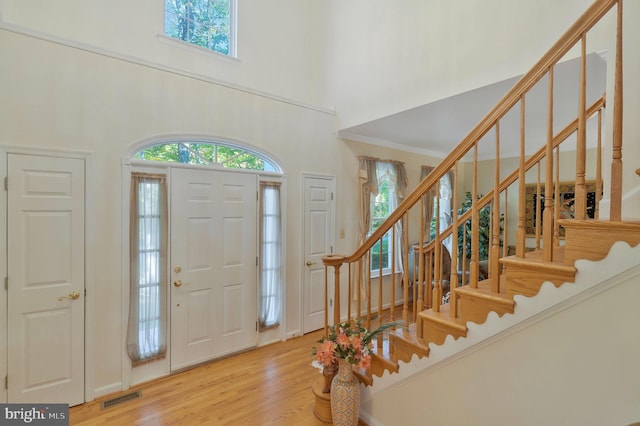 foyer with light wood-type flooring and a high ceiling