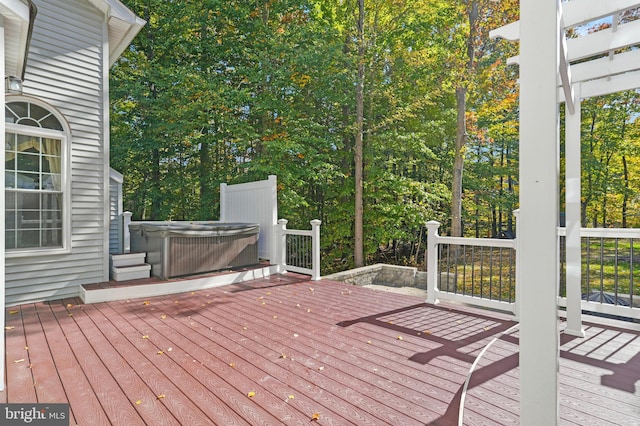 deck with a pergola and a hot tub