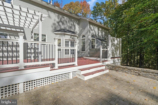 back of property featuring a pergola, a patio area, and a wooden deck