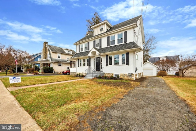 view of front of property featuring a garage, an outbuilding, and a front yard