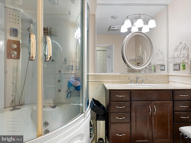 bathroom with vanity and enclosed tub / shower combo