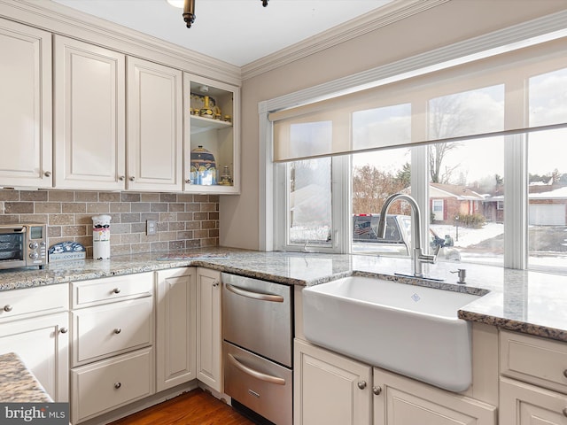 kitchen featuring sink, hardwood / wood-style floors, backsplash, and light stone counters