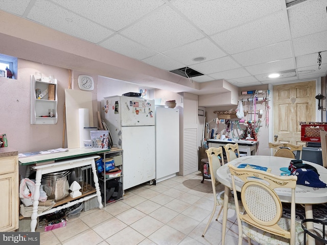 kitchen with light tile patterned floors, a paneled ceiling, and white refrigerator