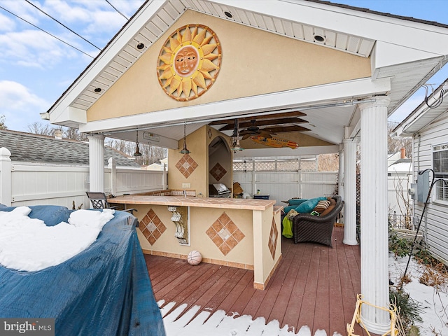 wooden terrace featuring ceiling fan and exterior bar