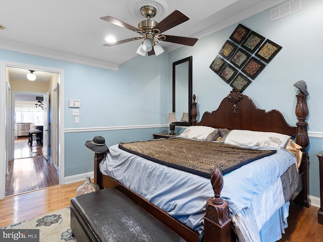 bedroom featuring ornamental molding, hardwood / wood-style floors, and ceiling fan