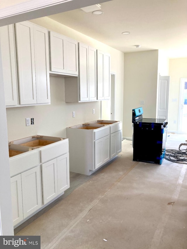 kitchen with white cabinets and concrete floors