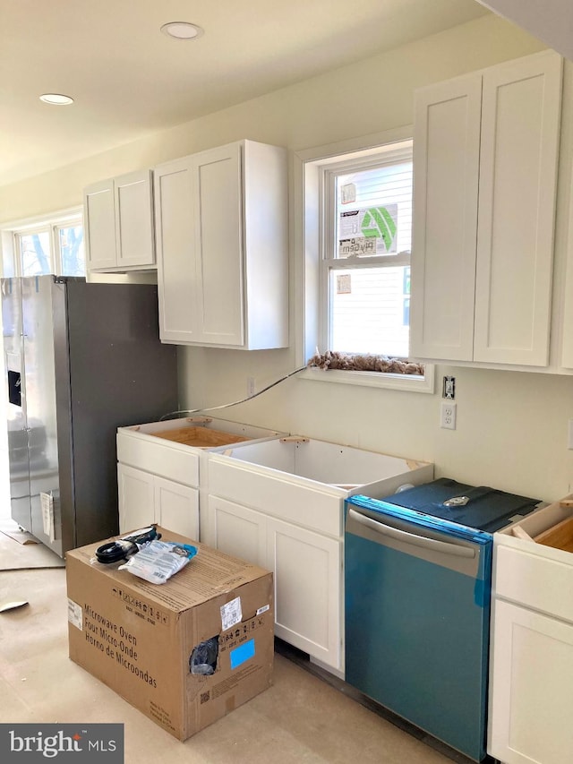 kitchen featuring white cabinets, dishwasher, stainless steel refrigerator with ice dispenser, a sink, and recessed lighting