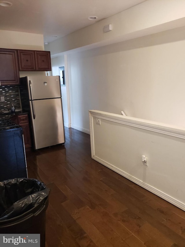 kitchen with gas stove, baseboards, dark wood-style flooring, and freestanding refrigerator