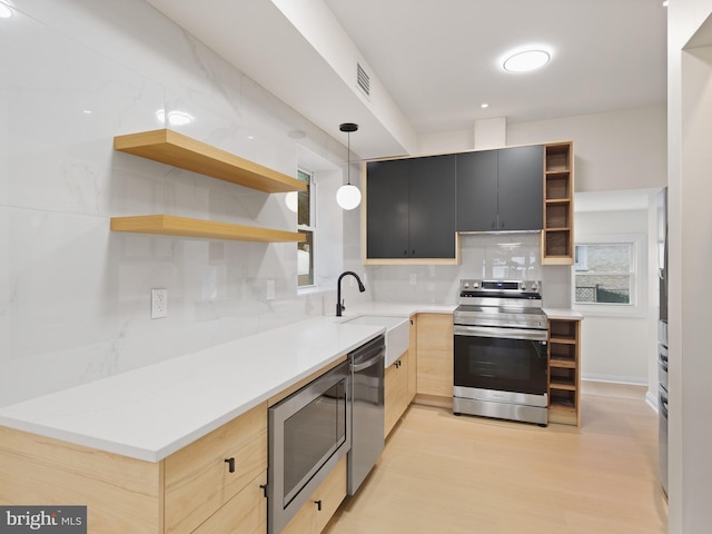 kitchen with appliances with stainless steel finishes, backsplash, sink, light hardwood / wood-style flooring, and hanging light fixtures