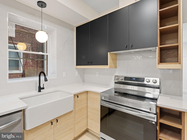 kitchen featuring sink, light brown cabinetry, stainless steel appliances, and hanging light fixtures