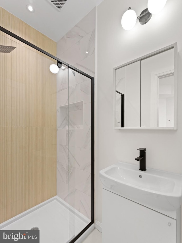 bathroom featuring vanity and an enclosed shower