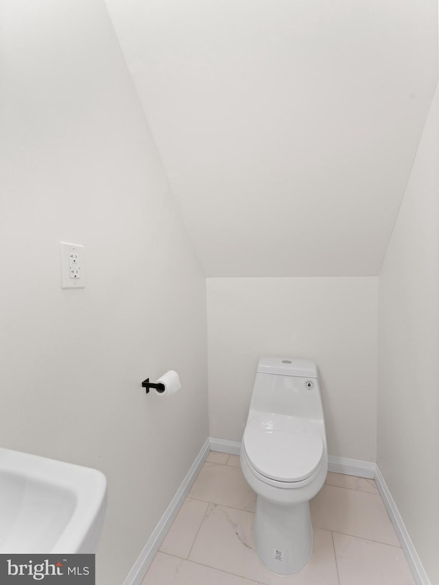 bathroom featuring toilet and lofted ceiling