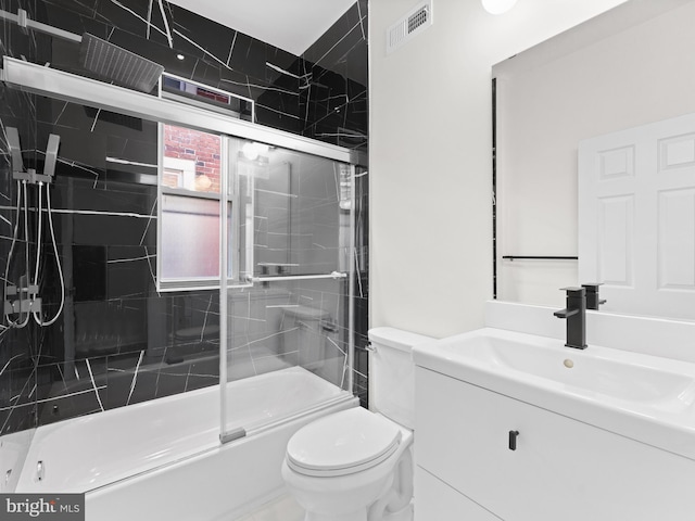 full bathroom featuring vanity, toilet, and bath / shower combo with glass door