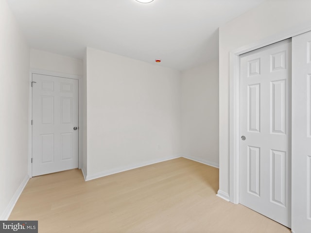 unfurnished bedroom featuring light hardwood / wood-style flooring and a closet